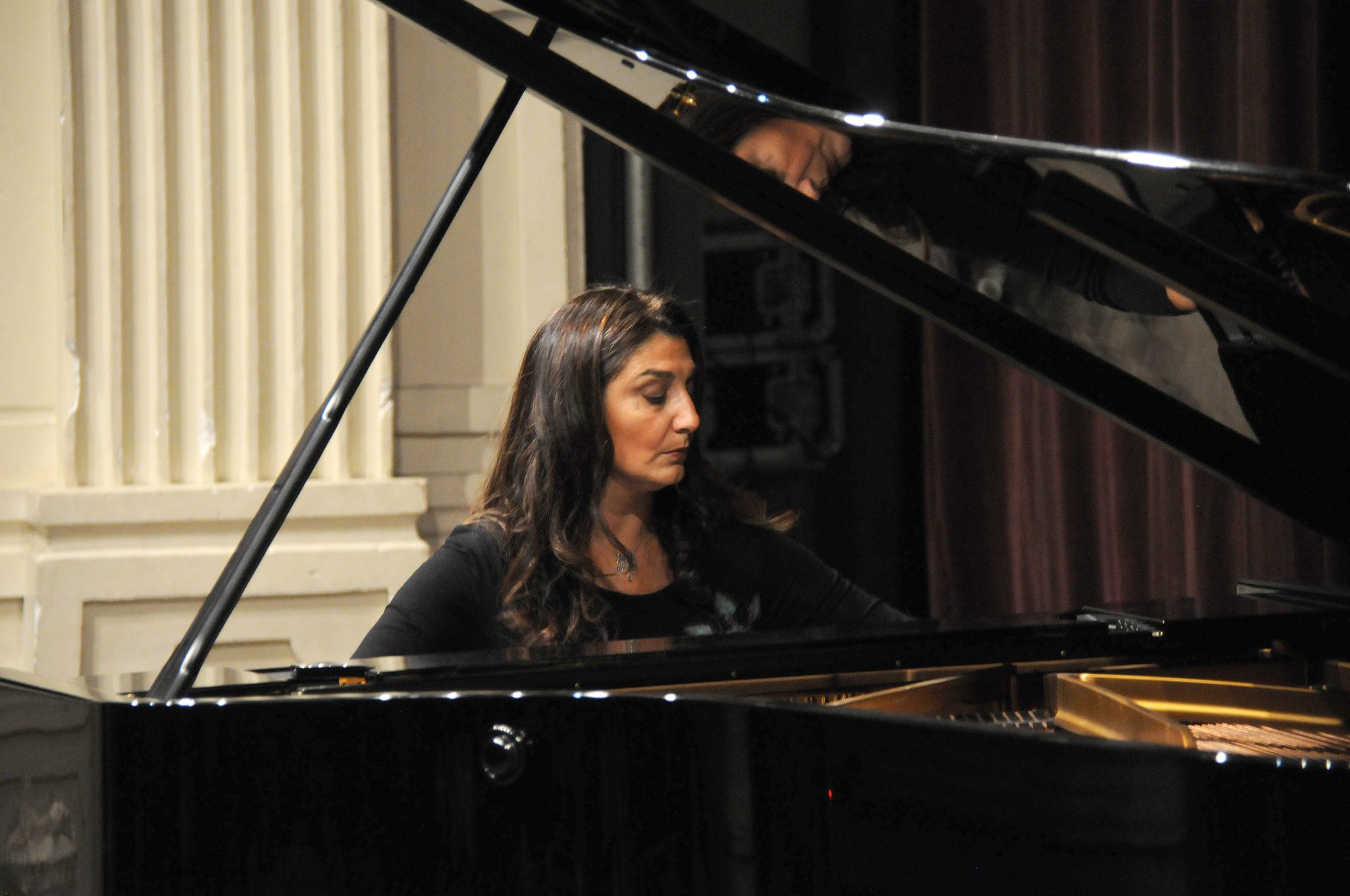 Elena Dabul tocando un piano de cola en concierto